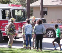 Family talking to firefighters outside home