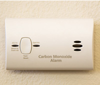 Carbon monoxide alarm on a tan colored wall.