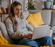 Woman sitting on couch looking at laptop