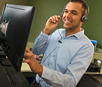 Man looking at computer talking on headset
