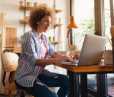 Small business owner looking at her laptop and smiling