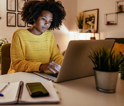 Woman at home, working on laptop in the evening
