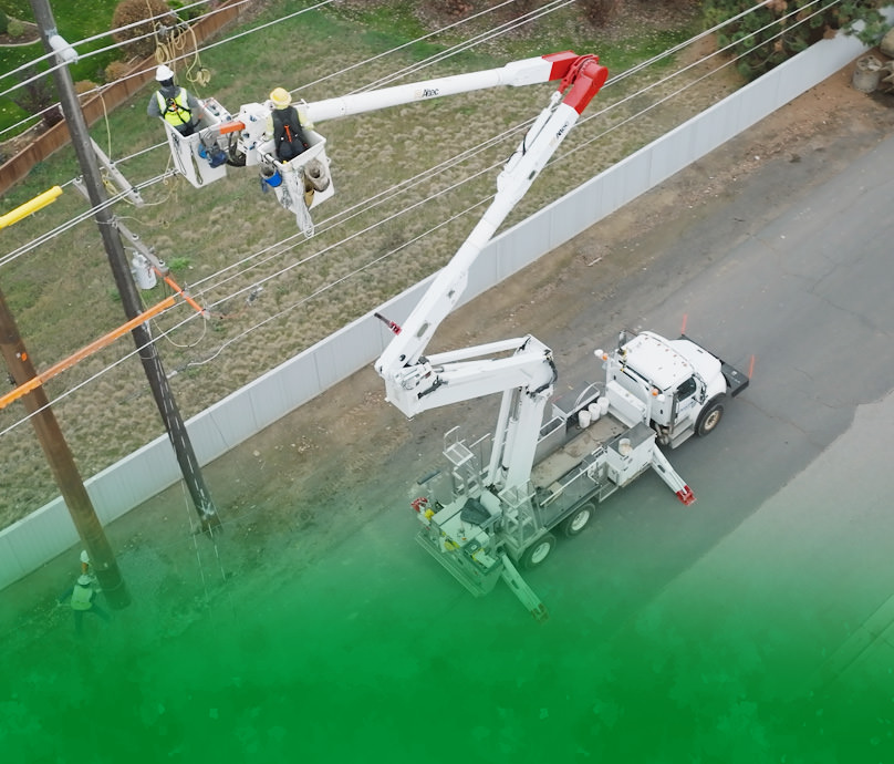 Linemen in bucket truck work on pole