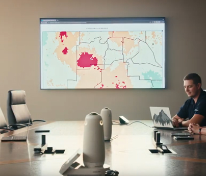 Electronic dashboard is shown on a TV screen during a meeting in the office