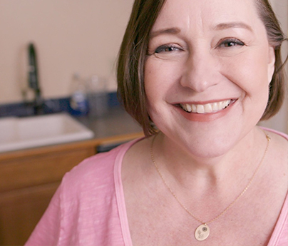 An Avista customer smiling in her kitchen