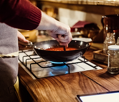 Man cooking over a natural gas stove.
